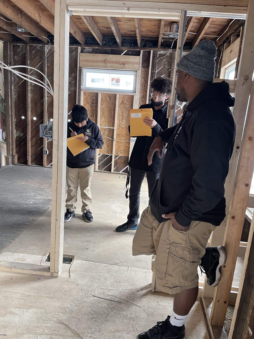 A K&K electrician walking students through a rough-in on site